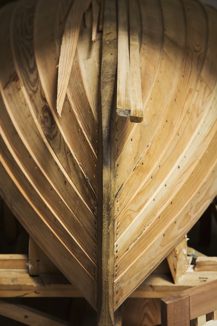 Close up of a wooden boat hull in a boat builder's workshop.